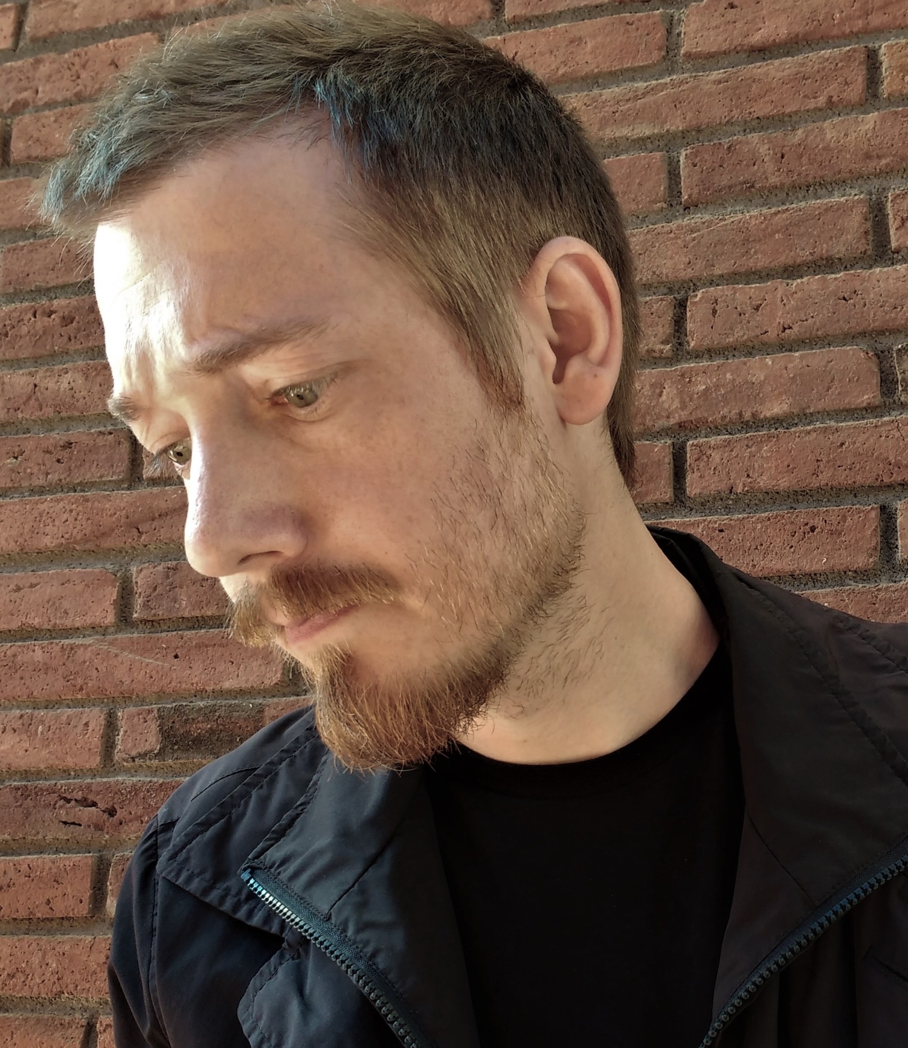 Retrato de Rubén Martín Giráldez junto a una pared de ladrillo
